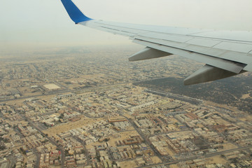 The flight of the plane over Dubai. Take off the airliner over the city. View from the porthole. Wing plane close-up. Background.