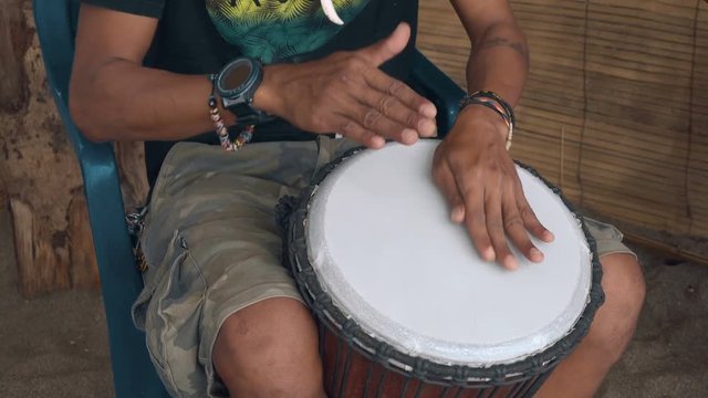 Close up of indonesian man hands playing Djembe Drum at night