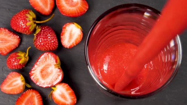 Strawberry smoothie flowing in glass in slow motion. Healthy drinking concept.
