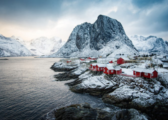 Famous tourist attraction Hamnoy fishing village on Lofoten Islands, Norway with red rorbu houses in winter. - obrazy, fototapety, plakaty
