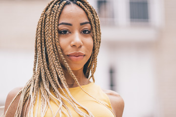 Afro woman with braids posing at camera.