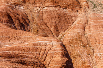 Red-orange layered mountains interspersed with light layers. Background.