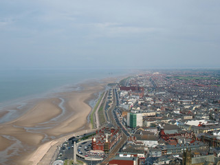 aerial view of blackpool looking south showing the beach at low tide with the roads and buildings of the town stretching down the coast to the irish sea on the horizon