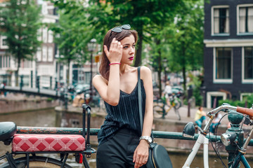 Fototapeta na wymiar portrait of a beautiful fashionable young girl in the streets of Amsterdam, the Netherlands in the spring evening