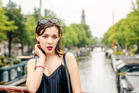 portrait of a beautiful fashionable young girl in the streets of Amsterdam, the Netherlands in the spring evening