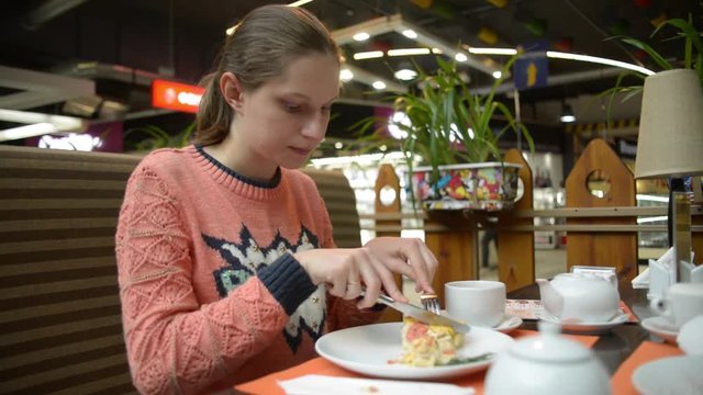 Pregnant woman eating cake at the mall cafe