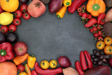 Super food healthy eating background border of fresh fruit and vegetables on slate. Health promoting concept with foods high in antioxidants, fibre, anthocyanins and vitamins.