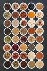 Healthy heart food ingredients with herbs and spices used in herbal medicine on slate background. Large collection high in vitamins, minerals, antioxidants, fibre and omega 3 fatty acids.