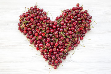 Fresh sweet cherries in heart shape, top view. Flat lay. From above.