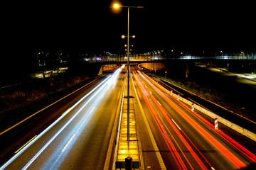 Fototapeta na wymiar Light trails, city lights and traffic lights on a highway that leads into the city centre of Copenhagen in Denmark. Taken from a bridge near a train station named Ryparken.
