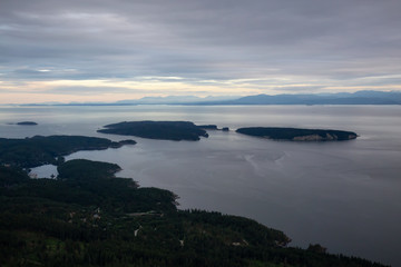 Aerial view of Sunshine Coast during a vibrant cloudy sunset. Located Northwest of Vancouver, British Columbia, Canada.