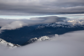 Aerial view of the striking Canadian Mountain Landscape covered in clouds. Taken North of Vancouver, British Columbia, Canada.
