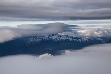 Obraz premium Aerial view of the striking Canadian Mountain Landscape covered in clouds. Taken North of Vancouver, British Columbia, Canada.