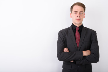 Young handsome businessman wearing suit against white background
