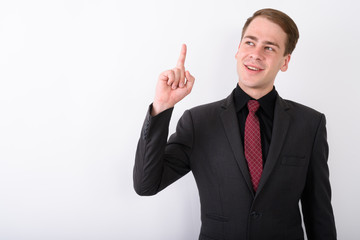 Young handsome businessman wearing suit against white background