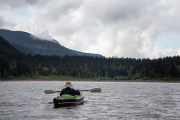 Fototapeta na wymiar Adventurous Man on a Kayak is enjoying the beautiful Canadian Mountain Landscape. Taken in Jones Lake, near Chilliwack and Hope, East of Vancouver, BC, Canada.