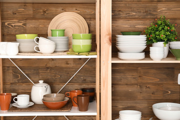 Fototapeta na wymiar Kitchen shelving with dishes on wooden wall background