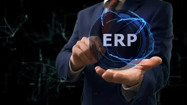 Businessman shows concept hologram ERP on his hand. Man in business suit with future technology screen and modern cosmic background