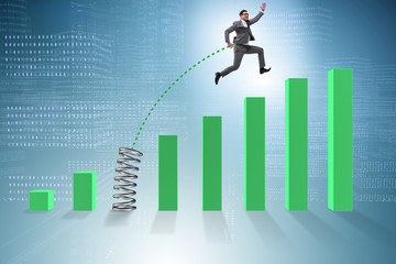 Business people jumping over bar charts