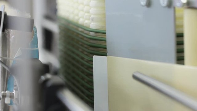 Factory process. Milk products labeling at dairy factory. Close up packing milk plastic bottles in slow motion