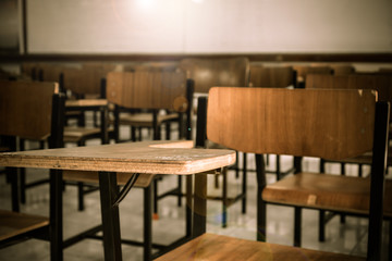 Lecture room or School empty classroom with desks chair iron wood for studying lessons in high school Thailand, interior of secondary education no kid teacher or young student, Vintage tone
