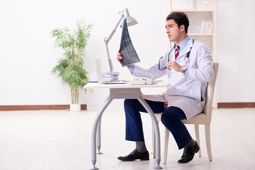 Young handsome doctor working in hospital room