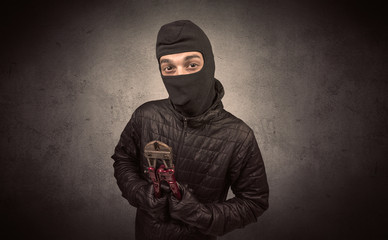 Burglar standing in black clothes and balaclava on his head.