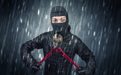 Burglar in action in black clothes with rainy concept. 
