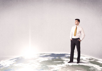 Fototapeta premium A young elegant office worker standing on top of a drawn world globe while celebrating his successful career concept.