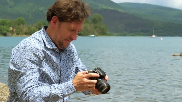 Man in front of lake in vacation taking pictures of ducks closeup