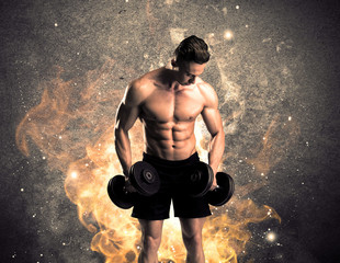 A strong athletic guy looking seductive while working out with weight in front of a burning fire...