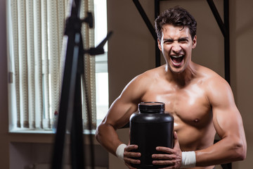 Man with nutrient supplements in sports gym