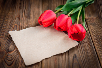 St. George ribbon, red tulips and paper greeting card on wooden background. Victory day or Fatherland defender day.