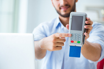 Man processing credit card transaction with POS terminal