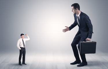 Big debutant young businessman scared of small strong businessman
