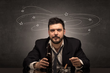Young drunk man at his office with doodles around
