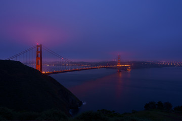Golden Gate bridge during sunrise with the city view background