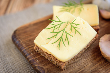 Crispbread with cheese on wooden background.