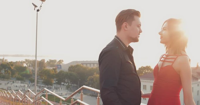 Romantic couple stand at the parapet against the backdrop of the city alley