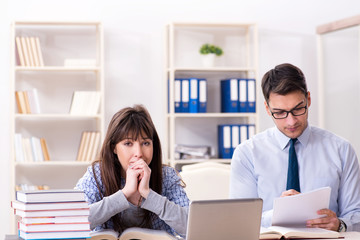 Male lecturer giving lecture to female student