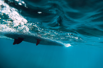 Stand up paddle board is underwater in ocean. SUP board
