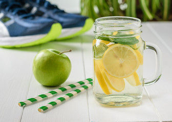 A mug of lemon and mint and two cocktail tubes with sneakers in the background.