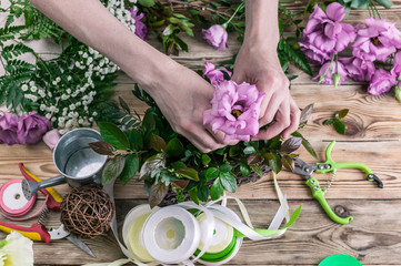 Florist at work. Female hands collect a wedding bouquet. People behind the work concept. The workplace of the florist.