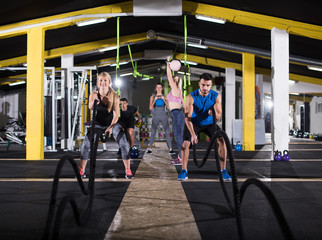 sports couple doing battle ropes cross fitness exercise