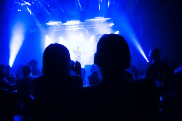 Crowd at concert and blurred stage lights .