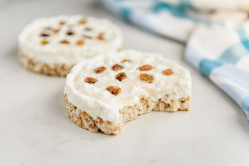 Homemade healthy sandwiches. Crisp bread with cottage cheese, baked milk and raisins on light background.