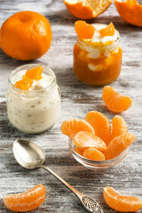 Slices of tangerines and yogurt. Delicious dessert on a white rustic background. Selective focus.