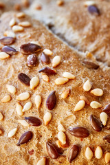 Close up picture of a whole wheat bread crust with flax and sesame seeds, selective focus.