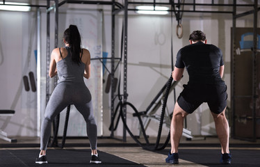 Fototapeta na wymiar sports couple doing battle ropes cross fitness exercise
