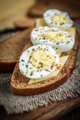 Boiled egg and cheese on whole wheat toast. Delicious and healthy breakfast. Selective focus
